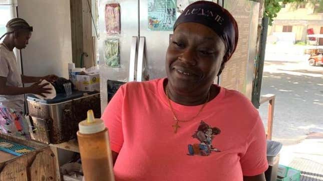 A waitress at Stuart’s Conch Stand holding the Bahamian Goat Pepper hot sauce.